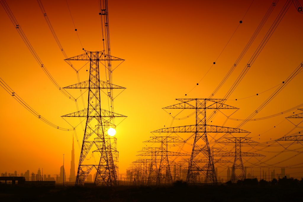 Transmission lines on a hot day with sun setting in background