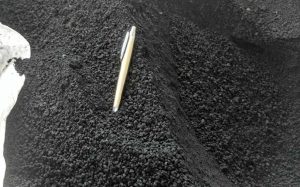 Sample of biochar with a pen planted in it
